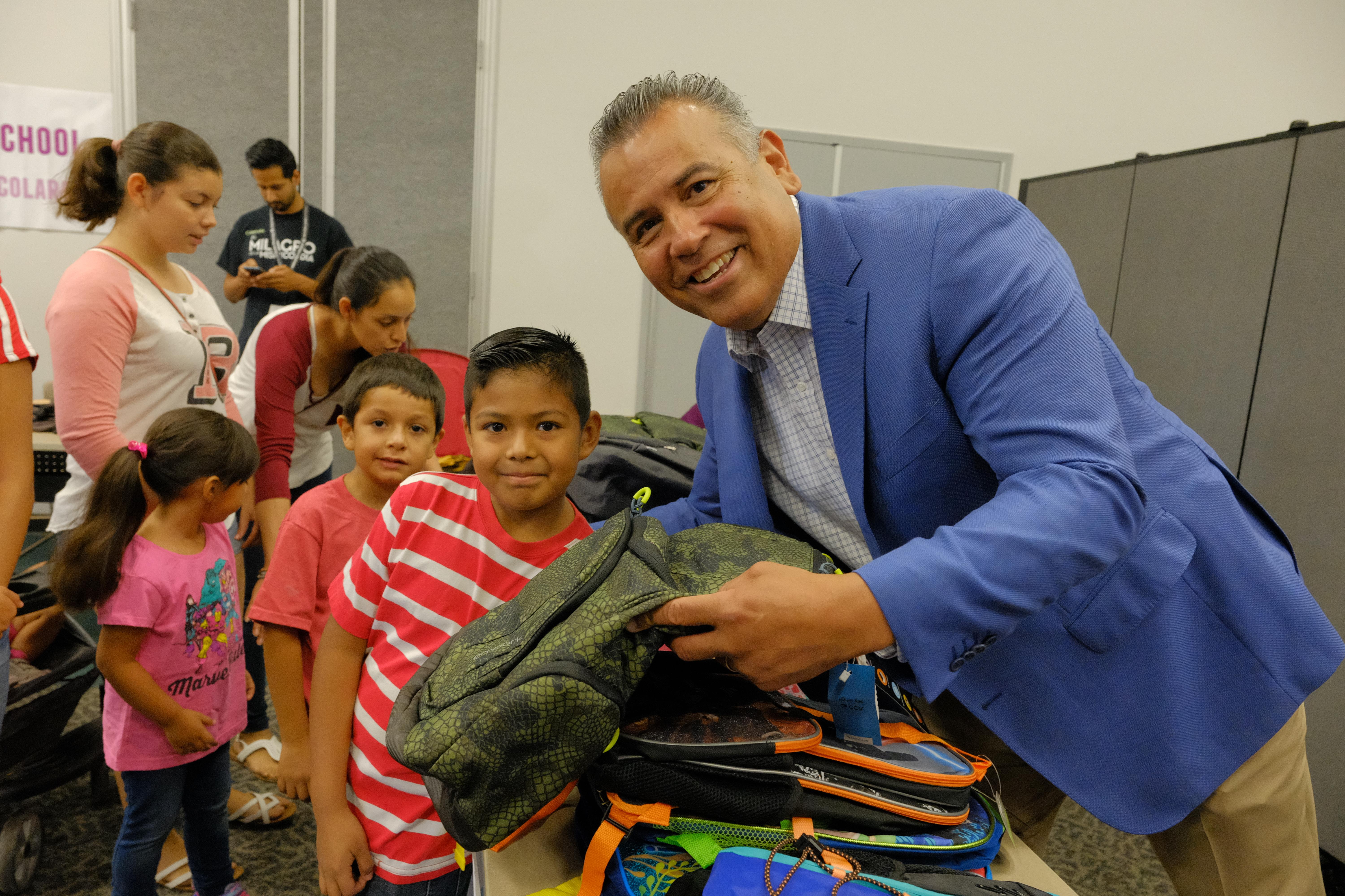 Superintendent Richard Martinez with student at the backpack giveaway.